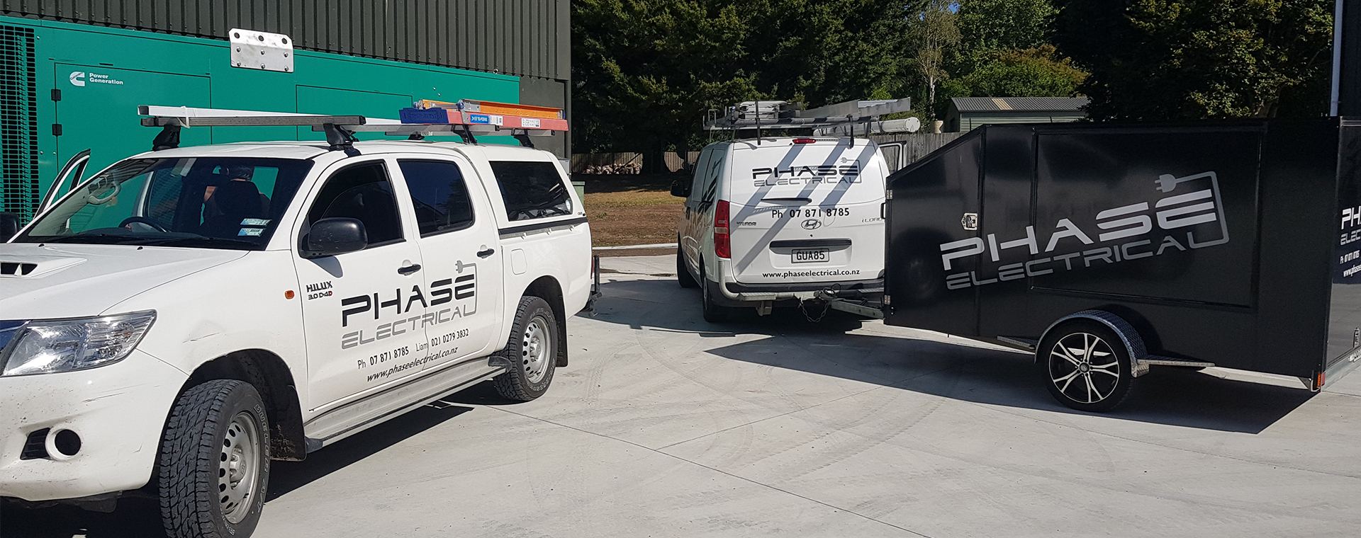 Phase Electrical Hilux, Hyundai van and branded trailer on a McFall Fuel Storage site next to a Cummins Power Generation cabinet