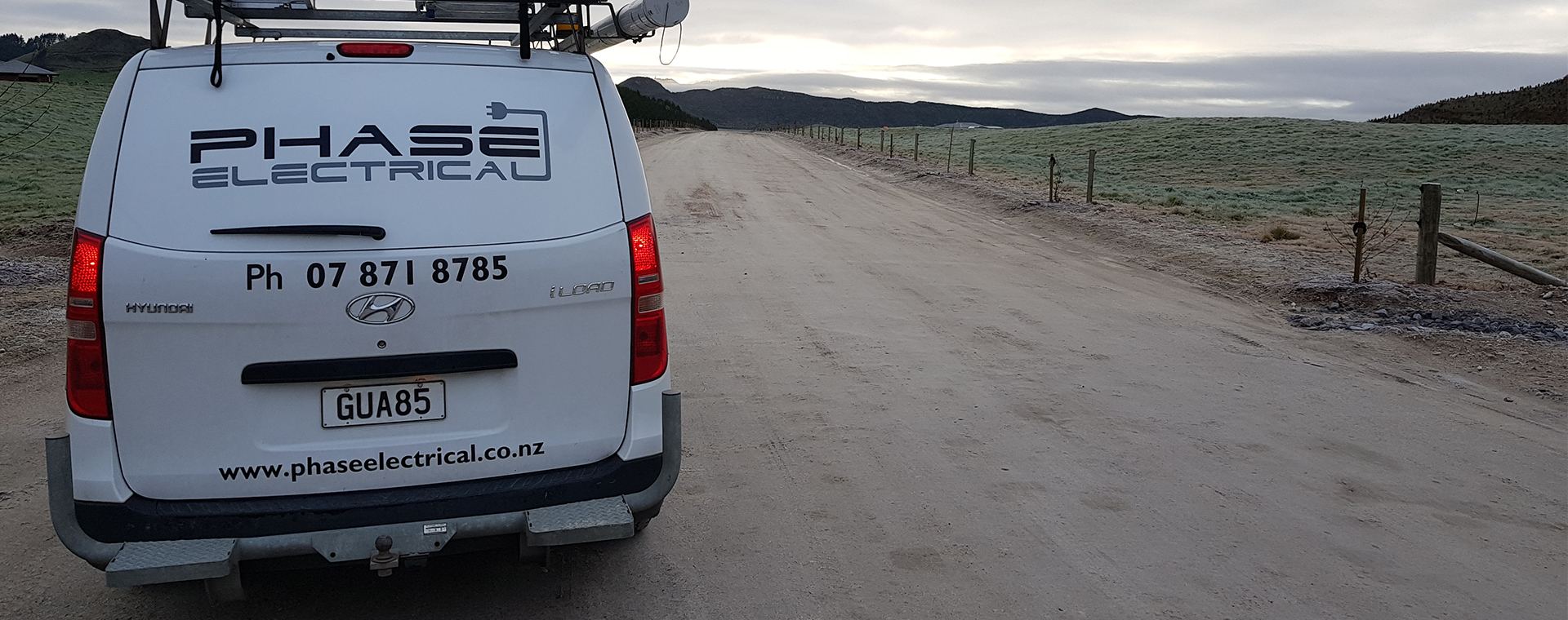 Phase Electrical van on a rural Waikato road at dawn with phone number painted on the back